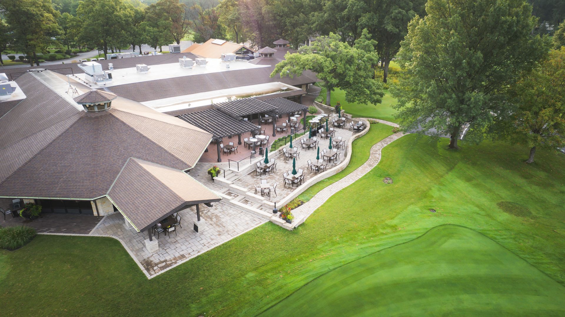 An aerial view of a golf course with a large building in the background.