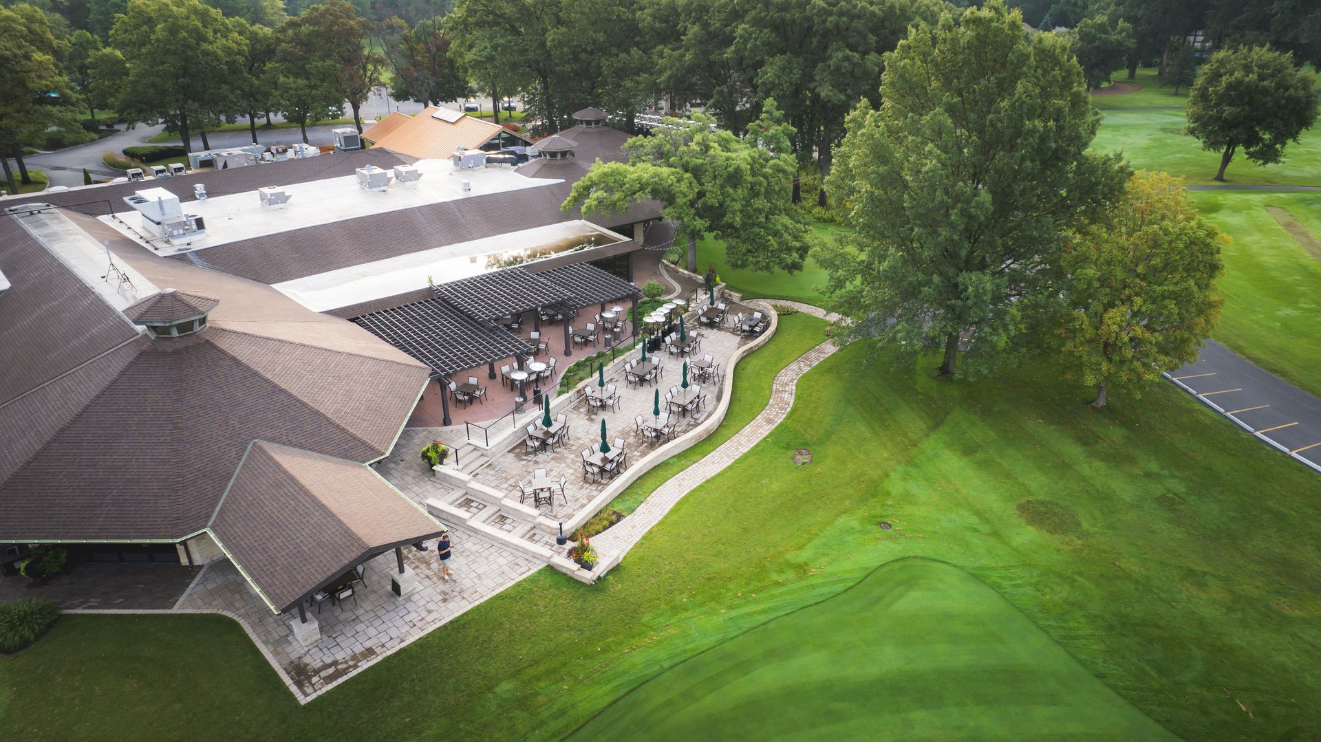 An aerial view of a golf course with a large building in the middle of it.