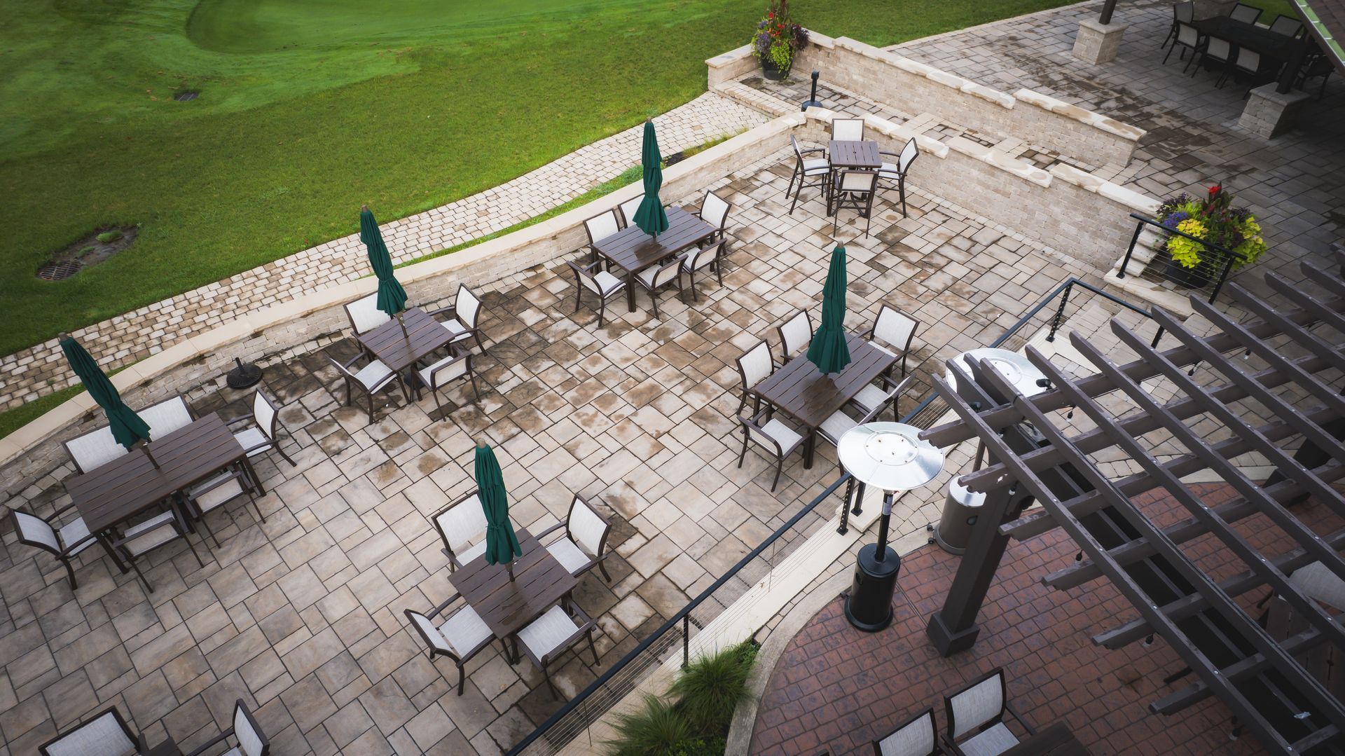 An aerial view of a patio with tables and chairs and umbrellas.