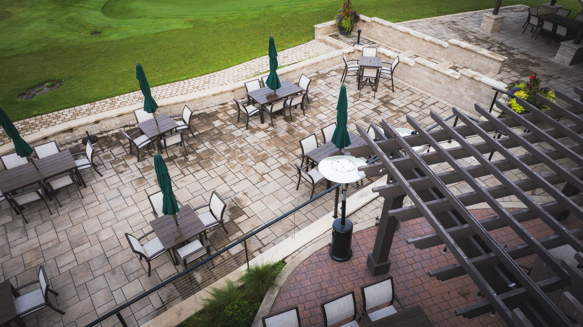 An aerial view of a patio with tables and chairs and umbrellas.