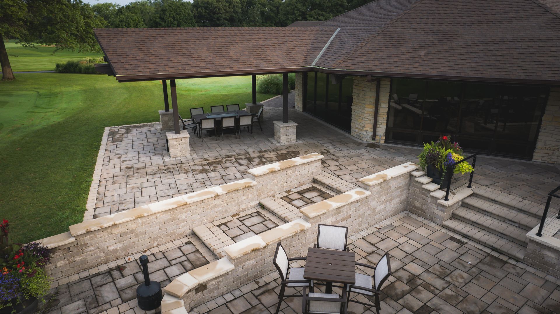 An aerial view of a patio with a table and chairs in front of a house.