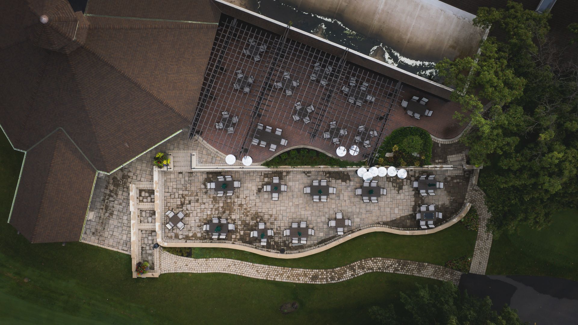 An aerial view of a patio with tables and chairs in front of a house.