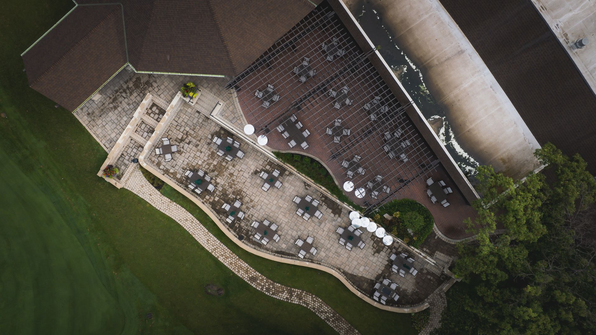 An aerial view of a restaurant with tables and chairs outside.