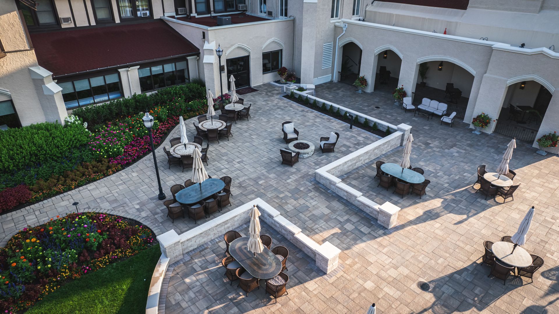 An aerial view of a patio with tables and chairs in front of a building.