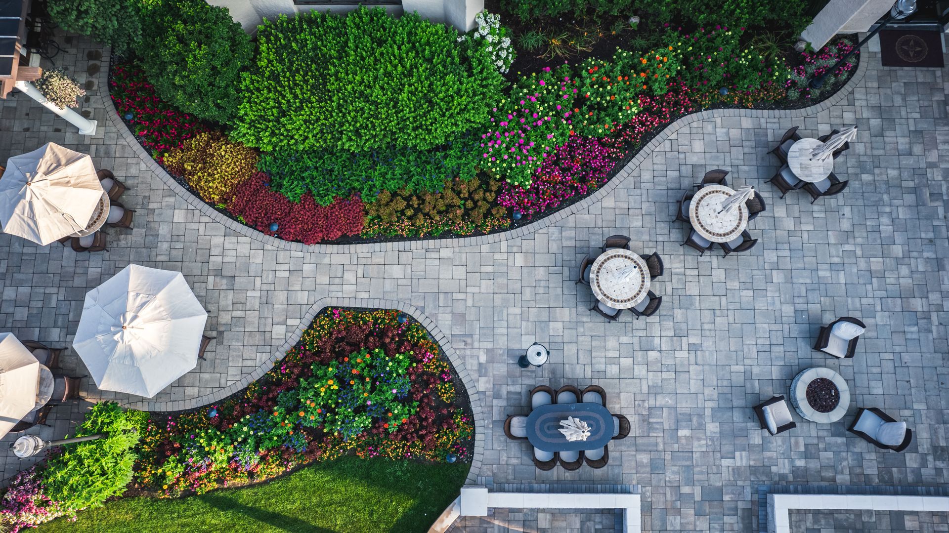 An aerial view of a patio with tables and chairs and umbrellas.