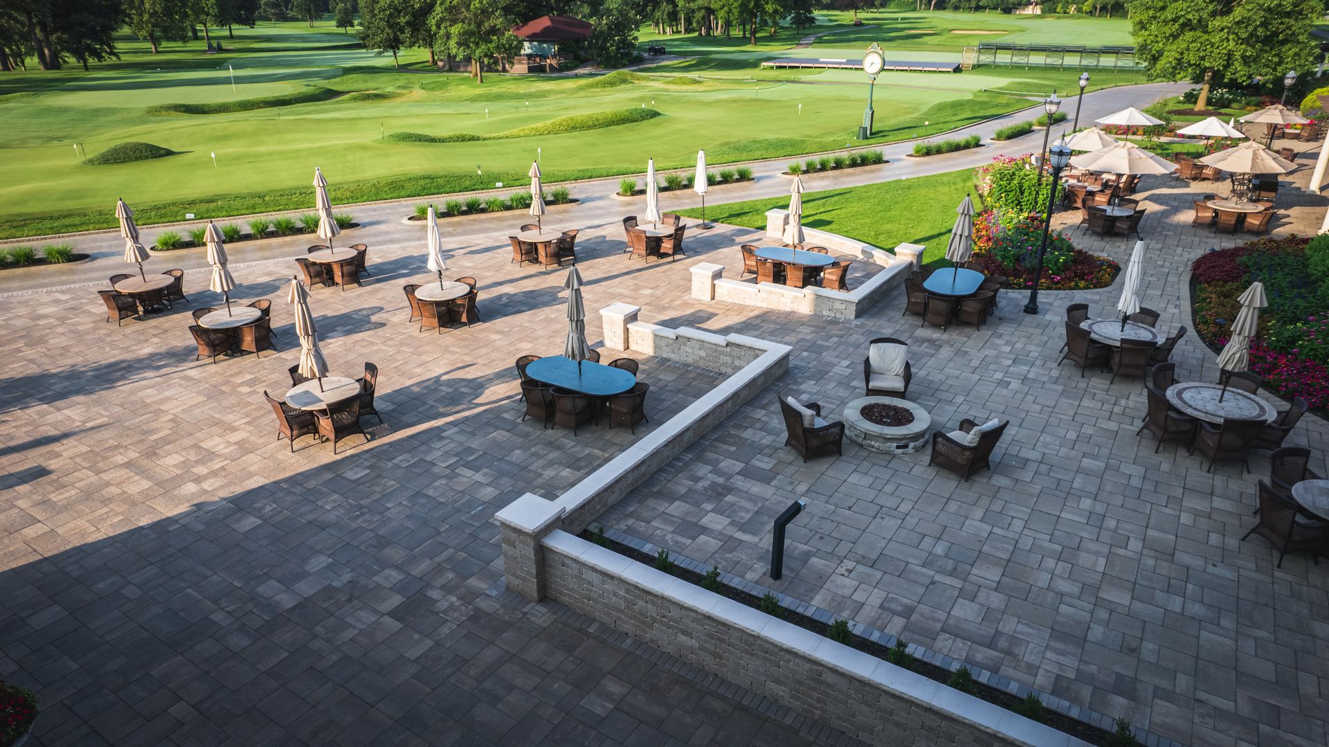 An aerial view of a patio with tables and chairs and a fire pit.