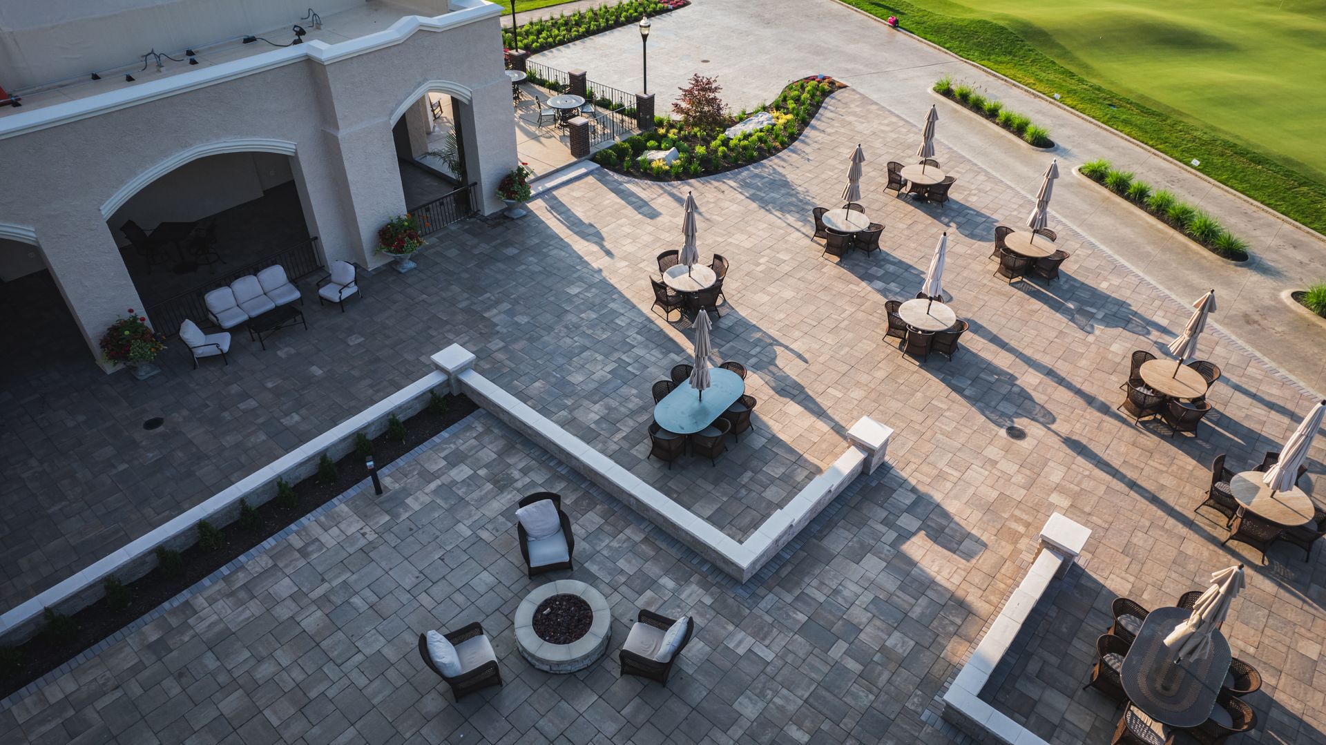 An aerial view of a patio with tables and chairs and umbrellas.