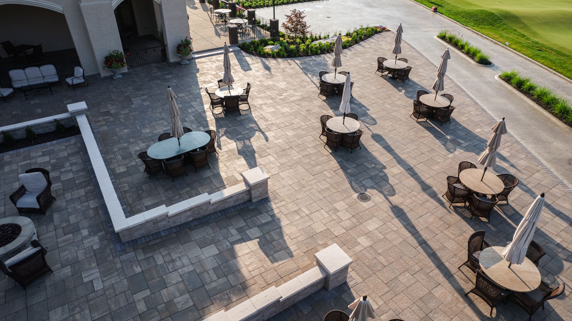 An aerial view of a patio with tables and chairs and umbrellas.