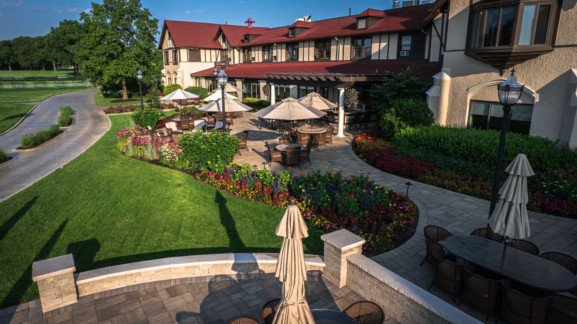 An aerial view of a large house with tables and umbrellas in front of it