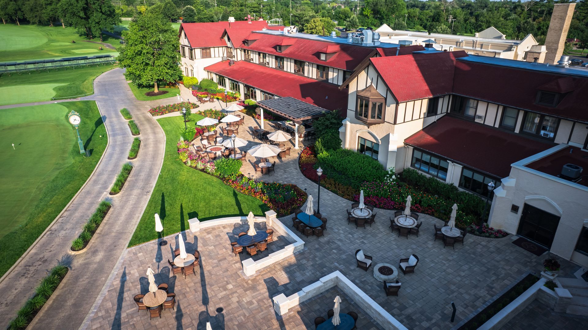 An aerial view of a large building with tables and chairs in front of it.