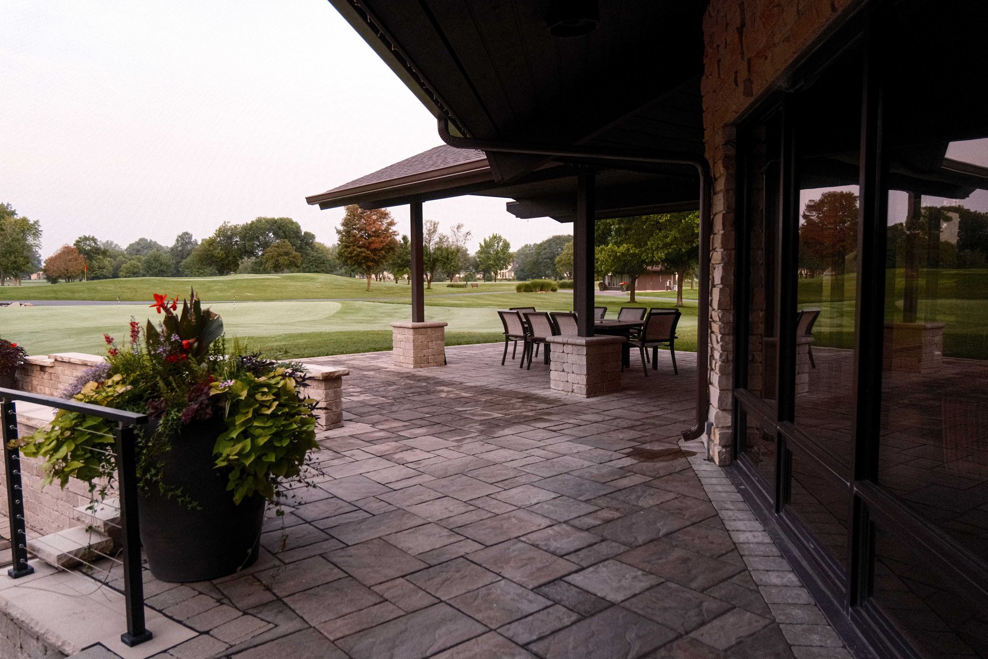A patio with a view of a golf course in the background