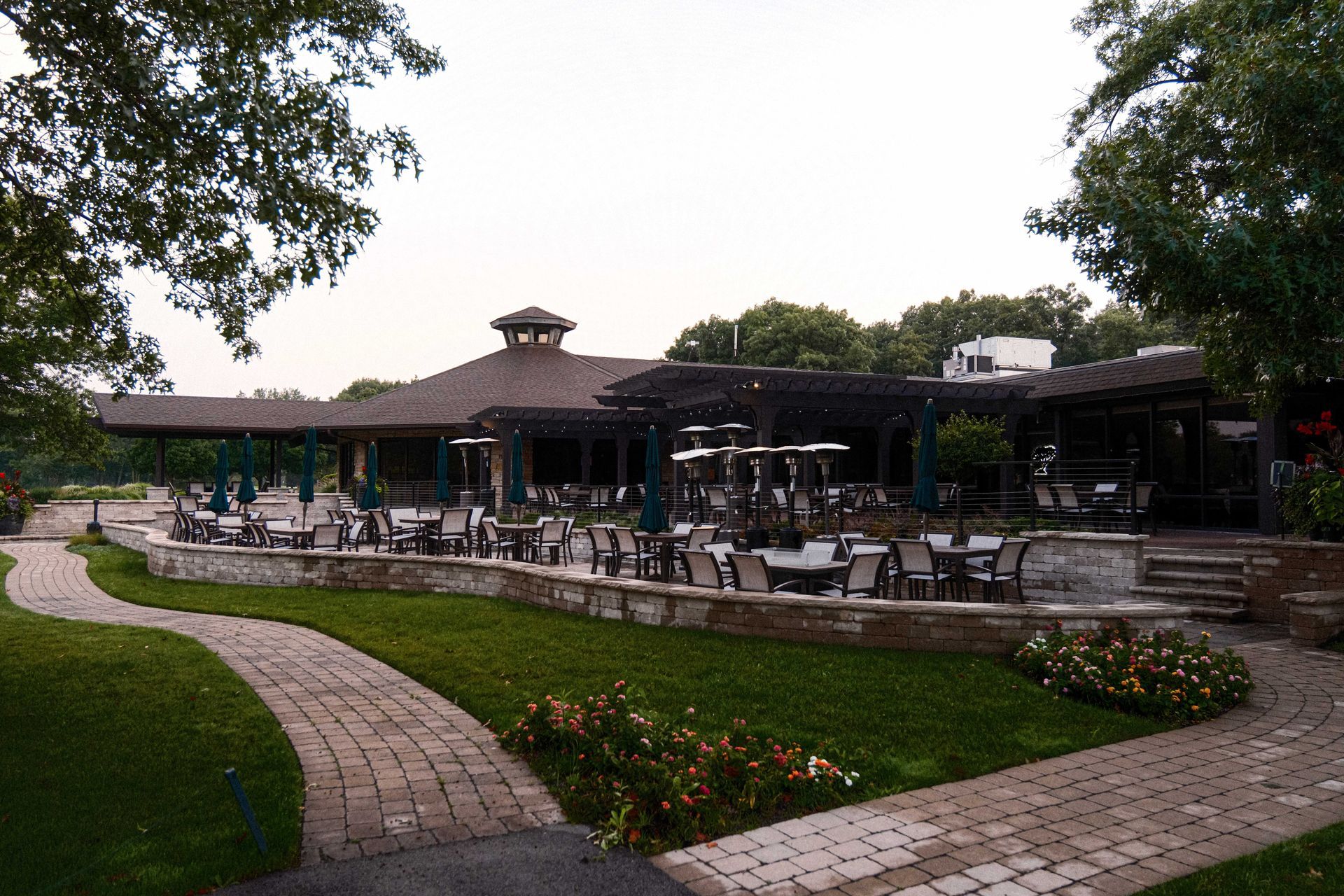 A large building with tables and chairs in front of it