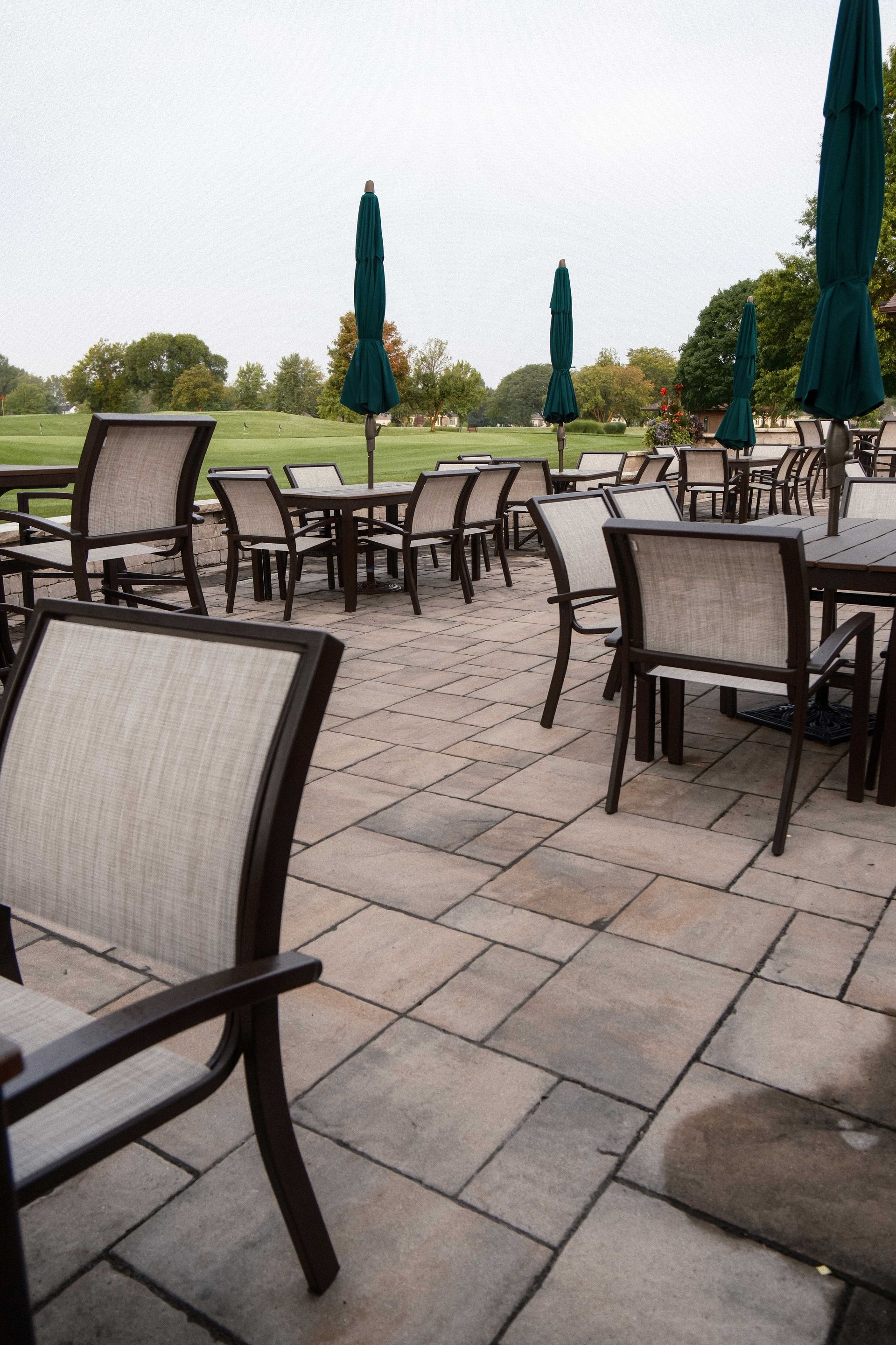 A patio with tables and chairs and umbrellas