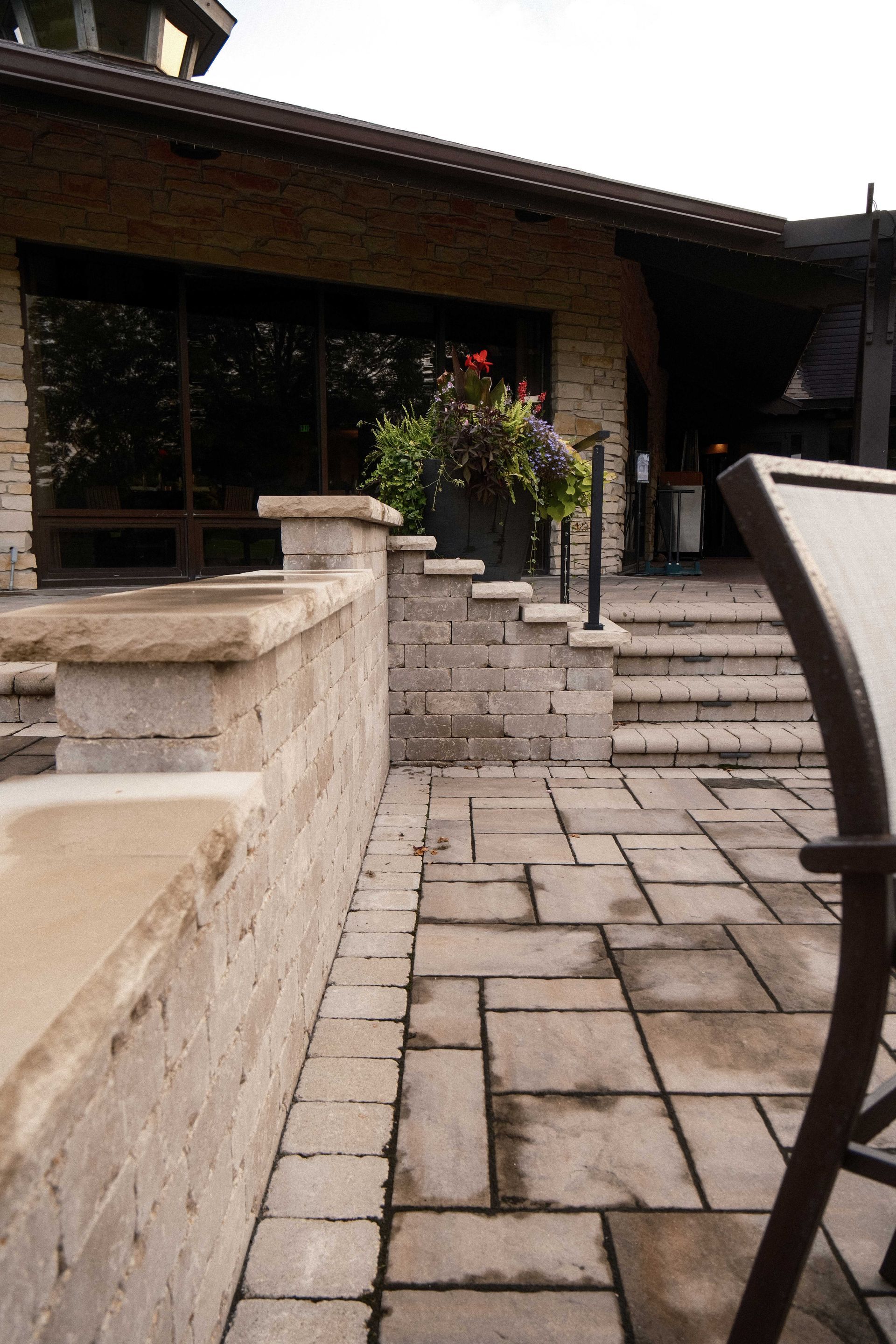 A chair is sitting on a patio in front of a house.