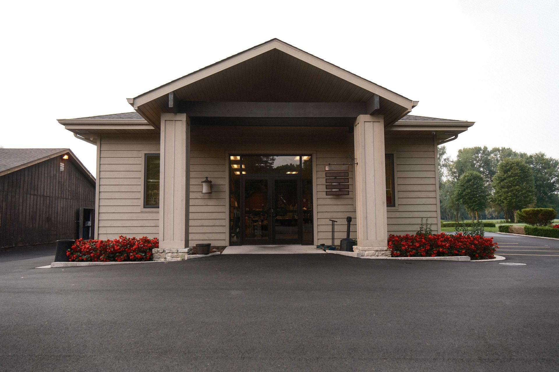 A small house with a porch and flowers in front of it