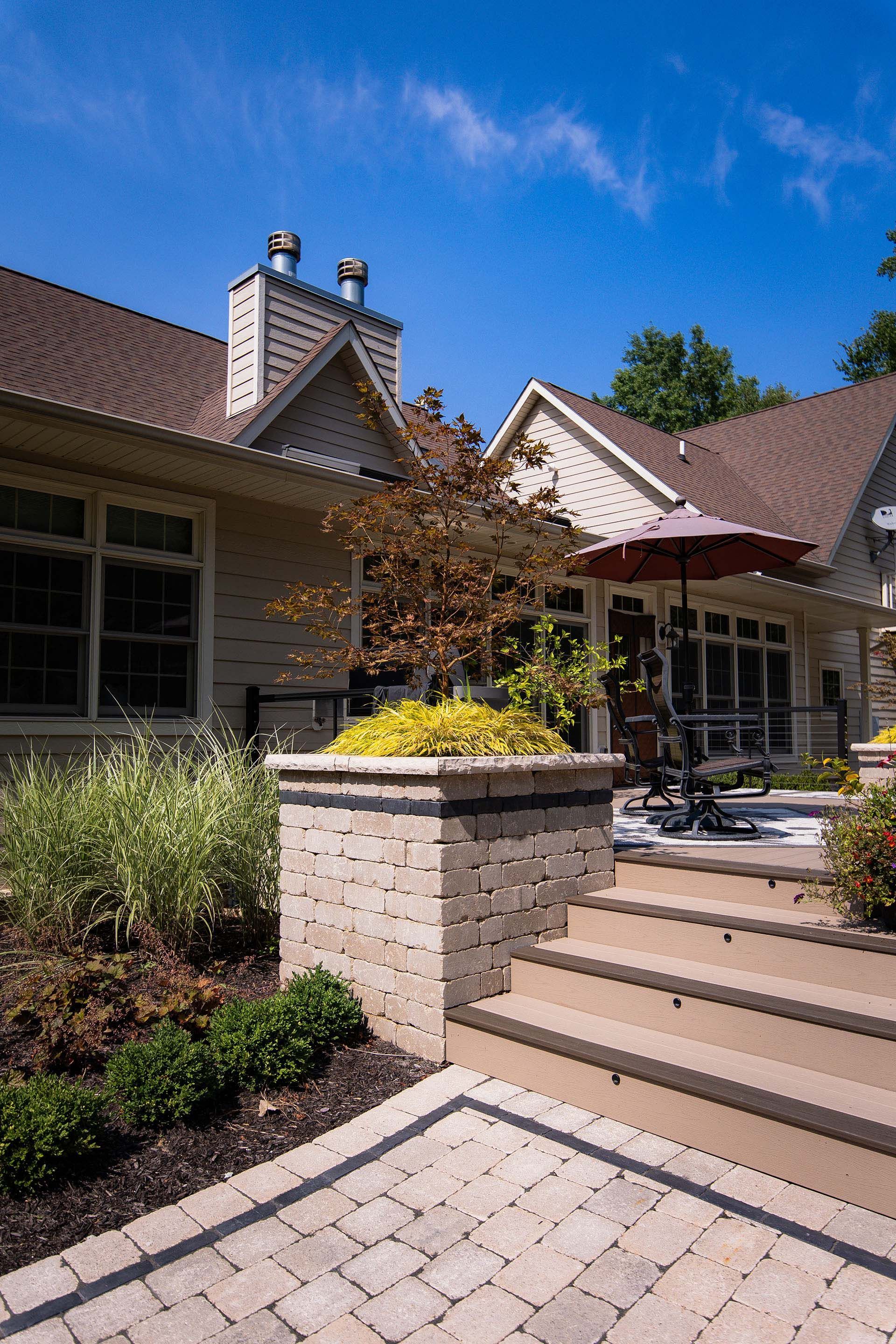 A large house with a patio and stairs in front of it.