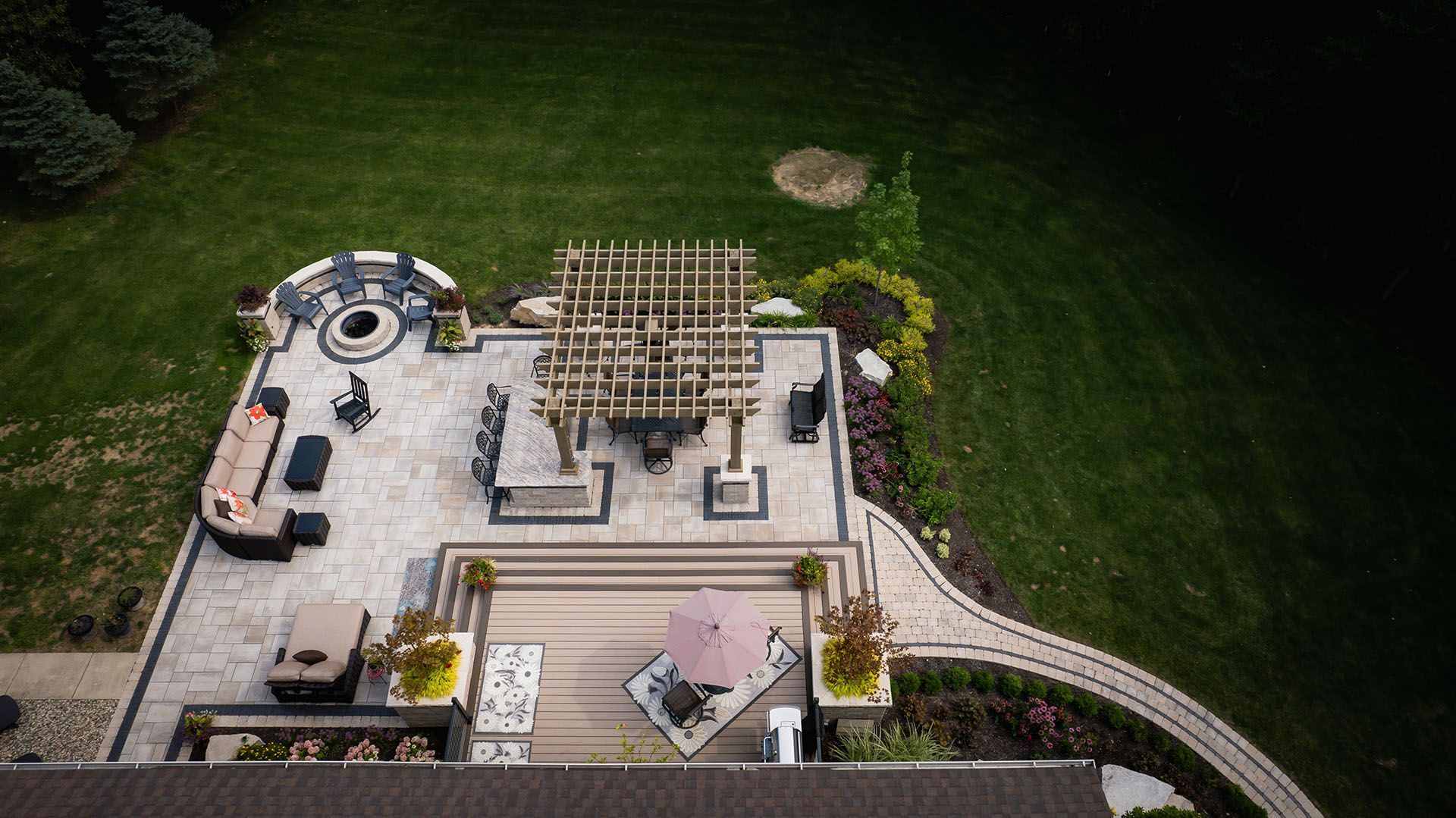 An aerial view of a large patio with furniture and a fire pit.