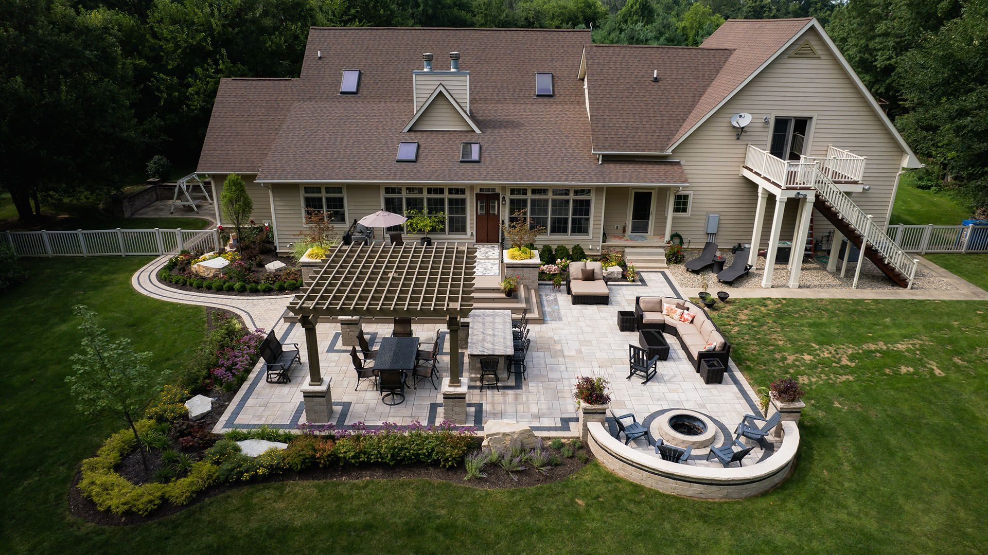 An aerial view of a large house with a patio and a fire pit.