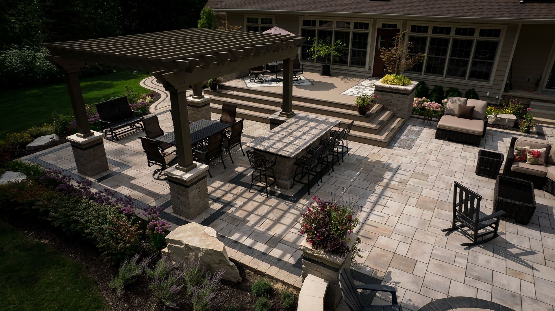 An aerial view of a large patio with a table and chairs under a pergola.