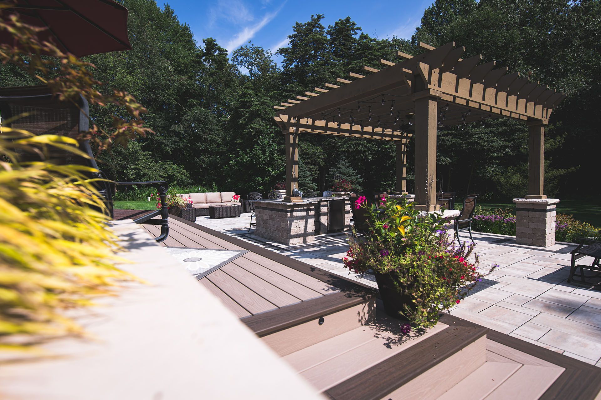 A patio with a pergola and flowers on it
