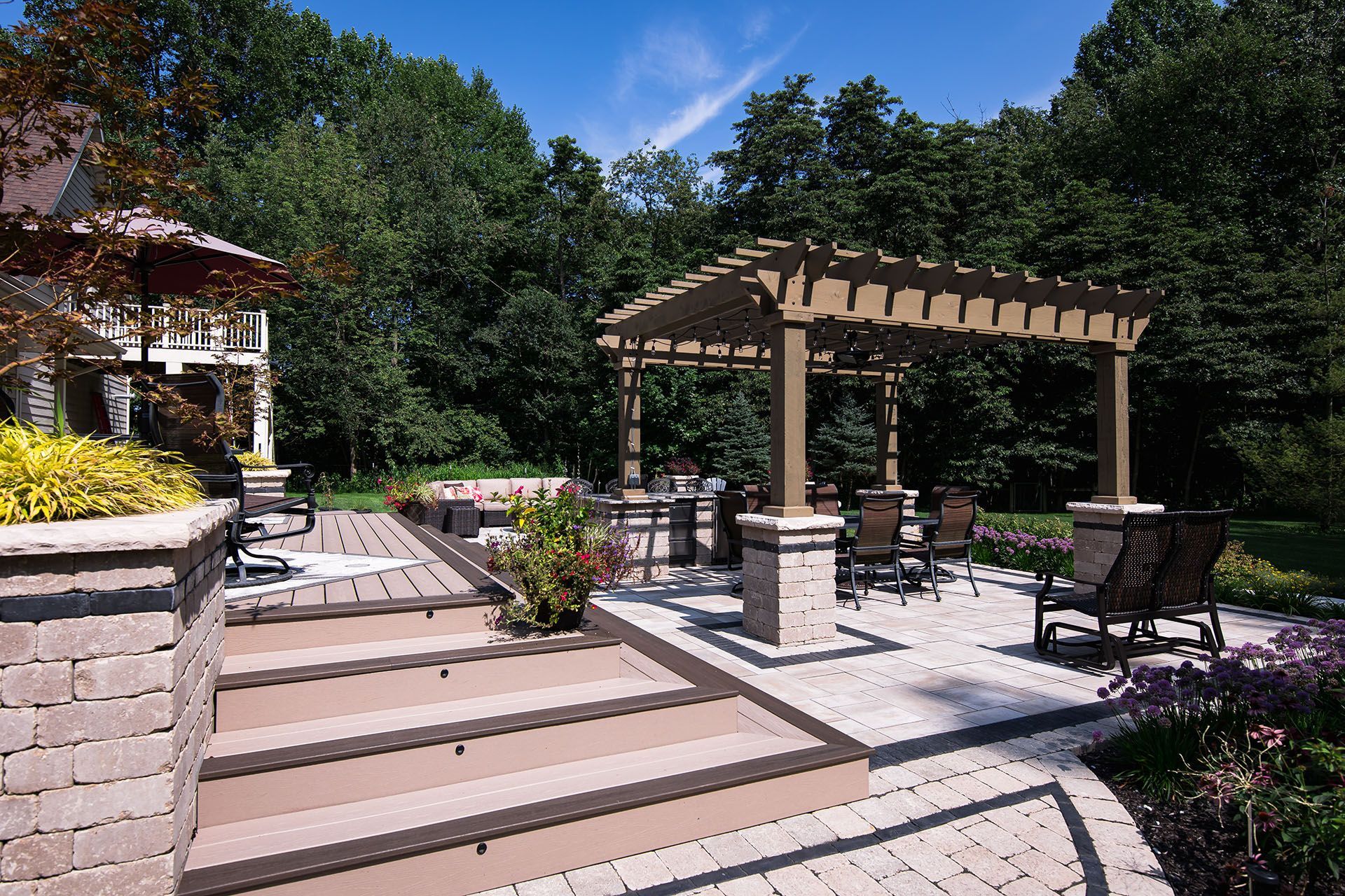A patio with a pergola and chairs in the backyard