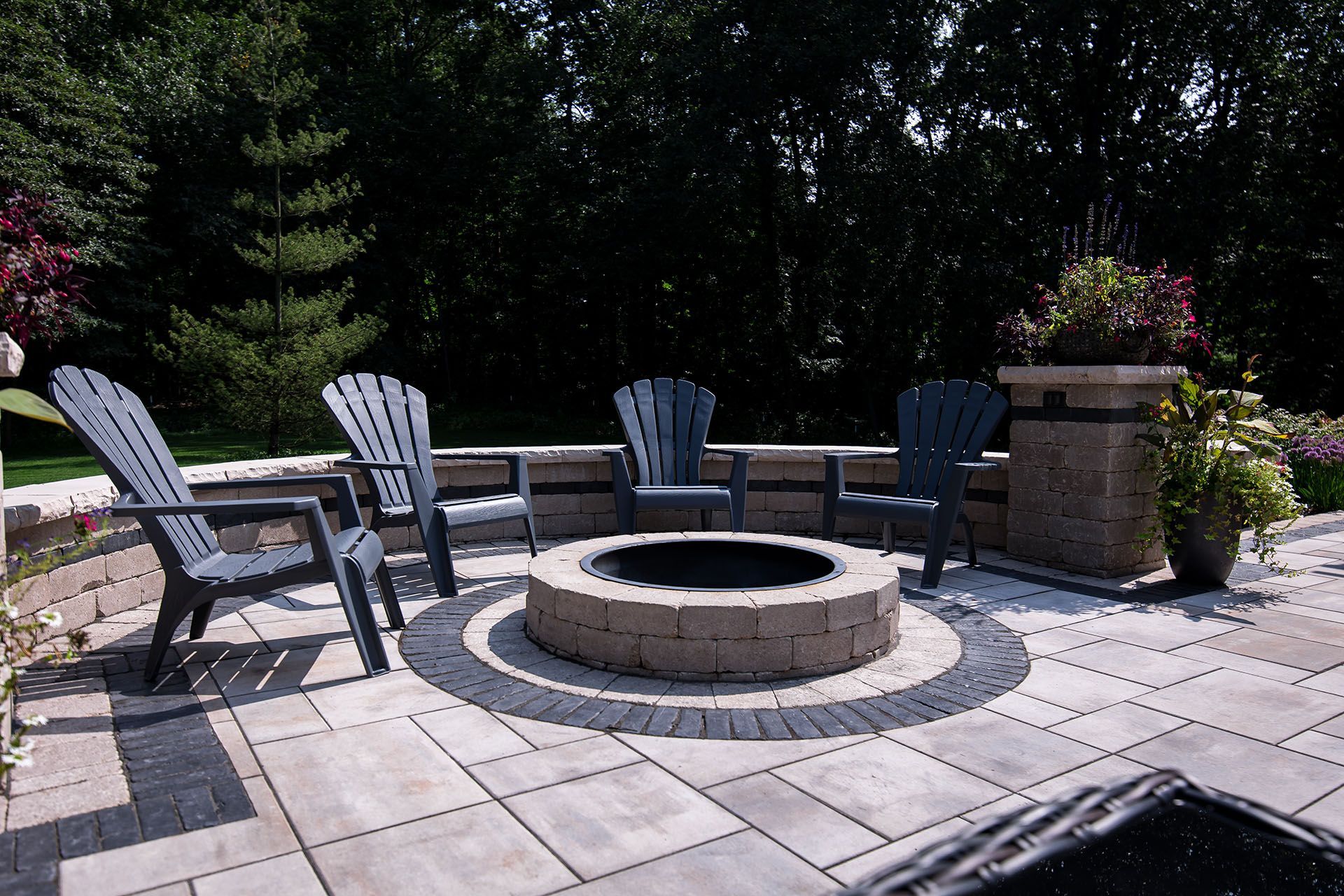A fire pit on a patio with chairs around it