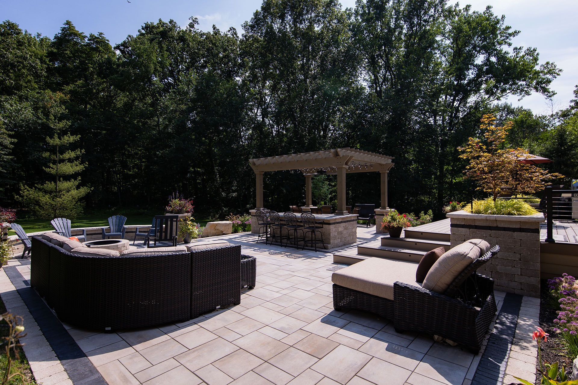 A large patio with a lot of furniture and trees in the background