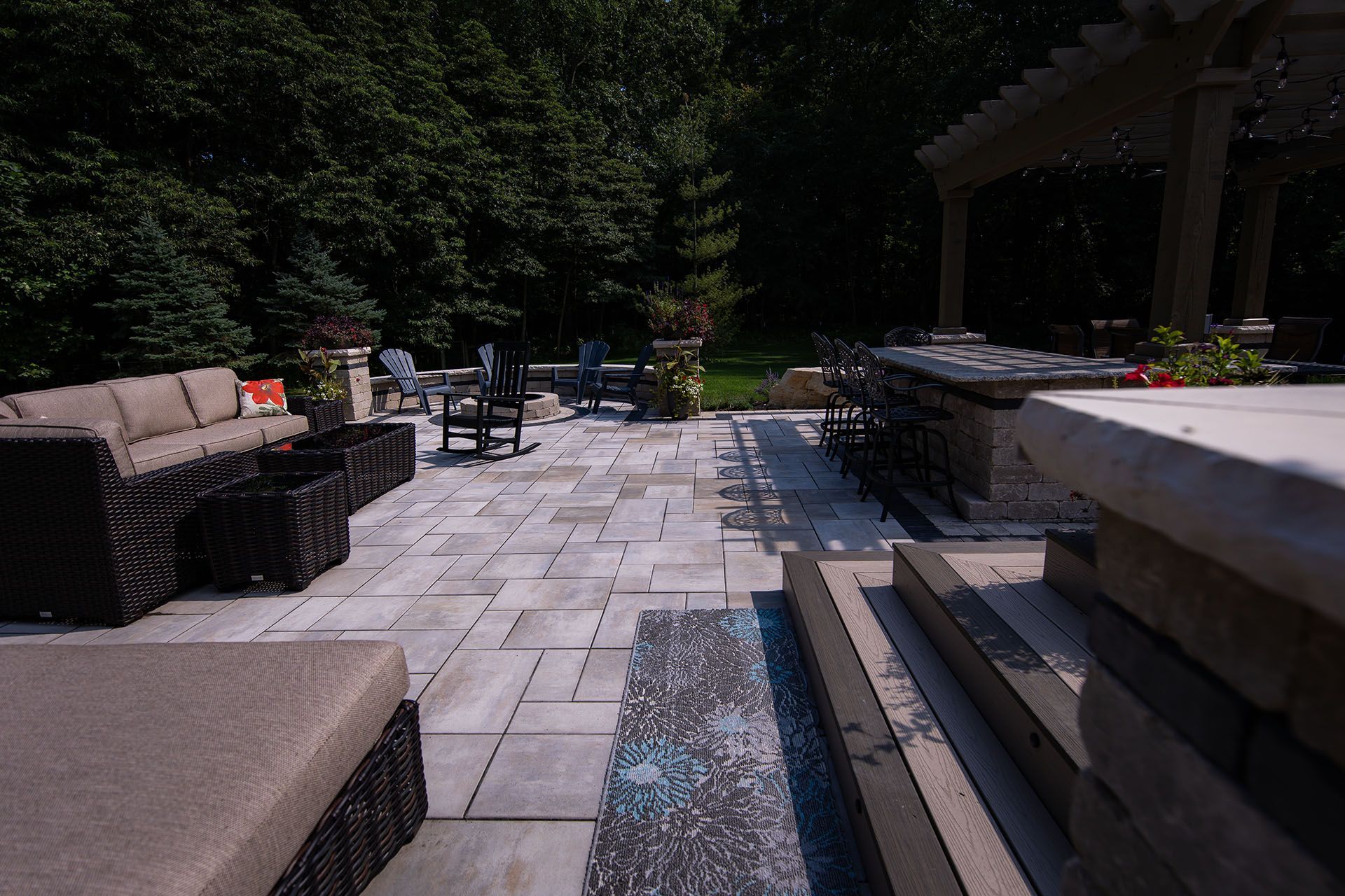 A patio with a couch and chairs and a fountain in the middle of it.