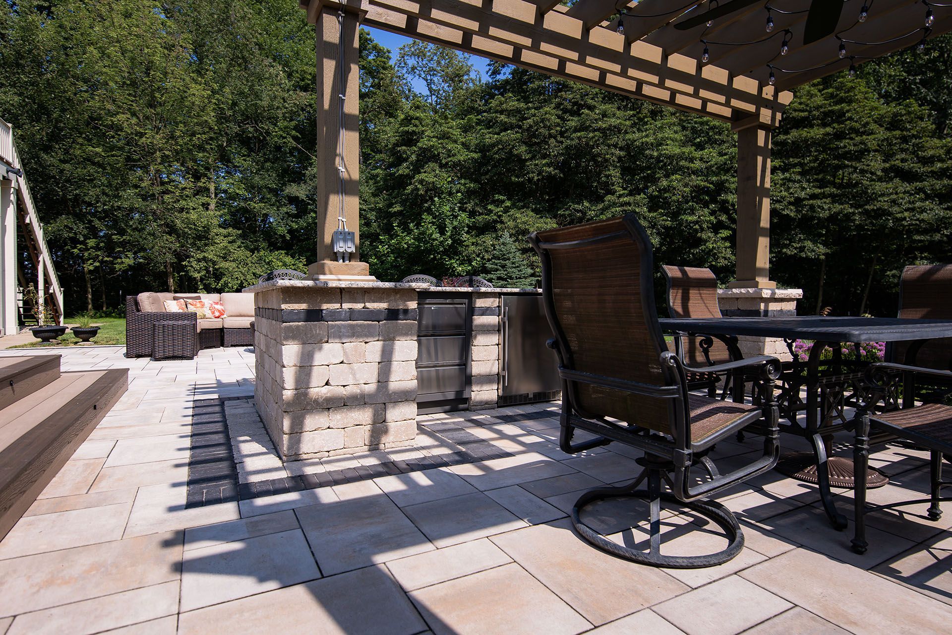 A patio with a table and chairs under a pergola.