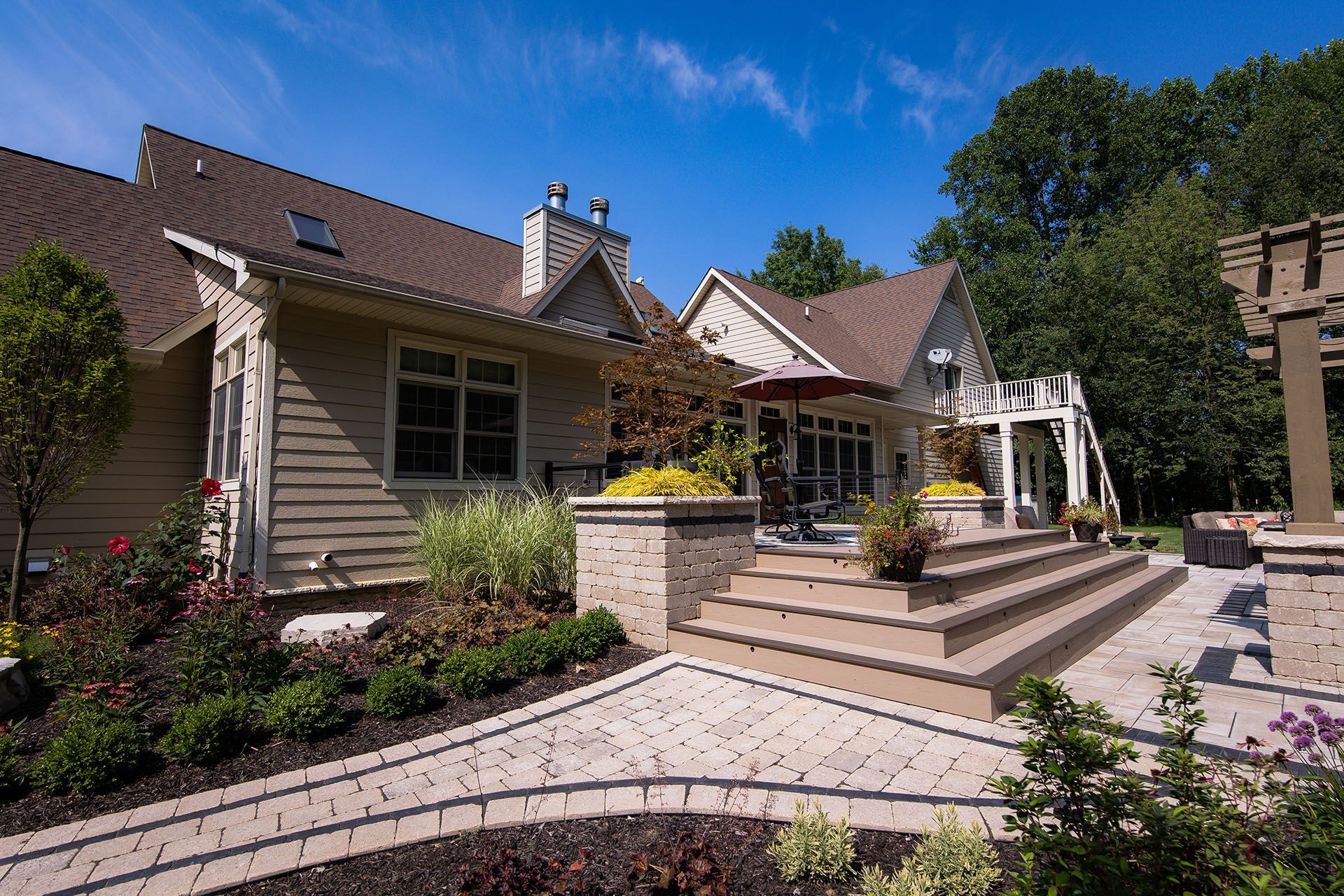 A large house with a patio and stairs in front of it.