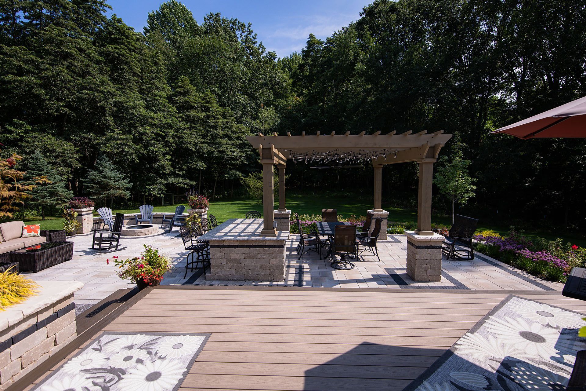 A large patio with a pergola and a table and chairs.