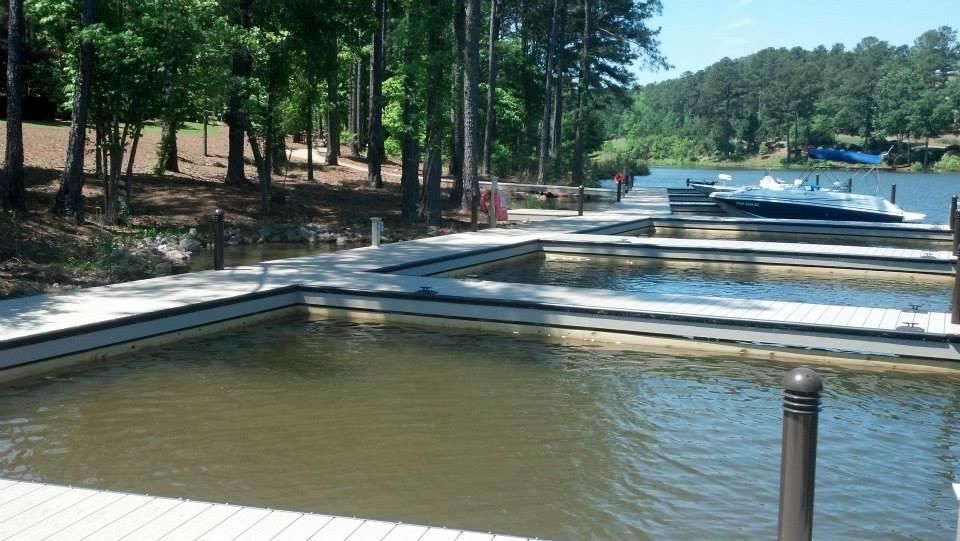 Dock with boat slips, surrounded by water. Trees line the shore in the background.