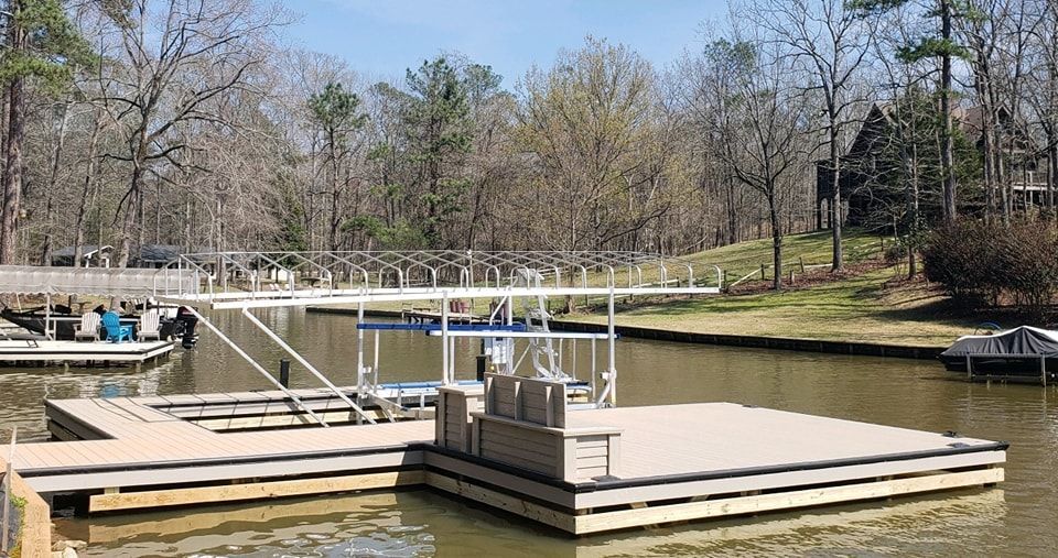 Dock with boats, surrounded by trees on a sunny day.