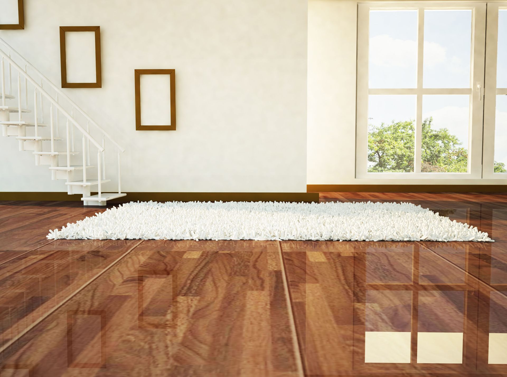 Empty bright room with hardwood floor, white rug, staircase, and sunlight by a window