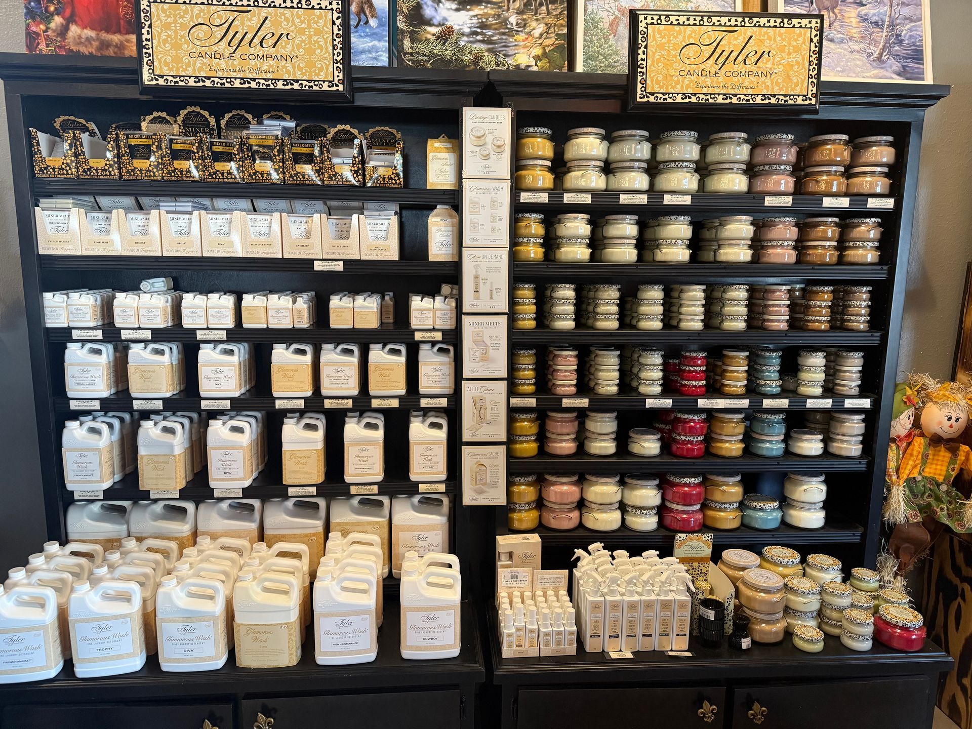 Shelves stocked with various candles and soaps in a store. Dark wooden furniture and soft lighting.