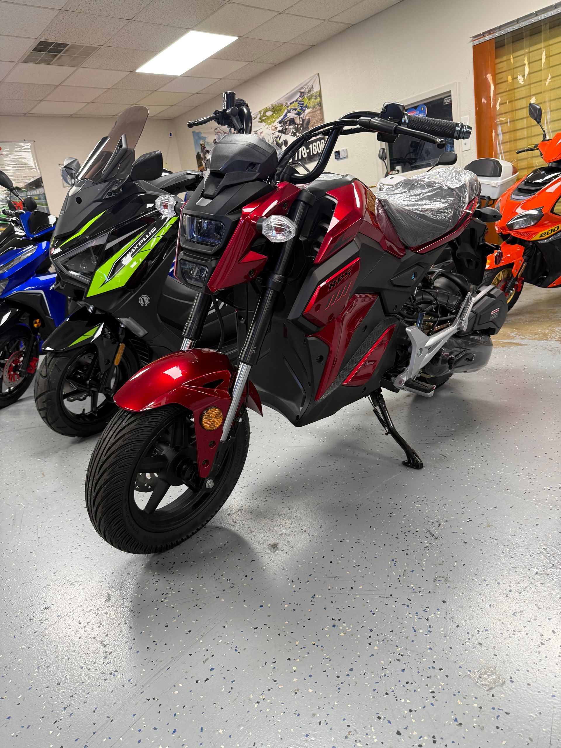 Row of colorful scooters in a showroom, with a red-and-black scooter in the foreground