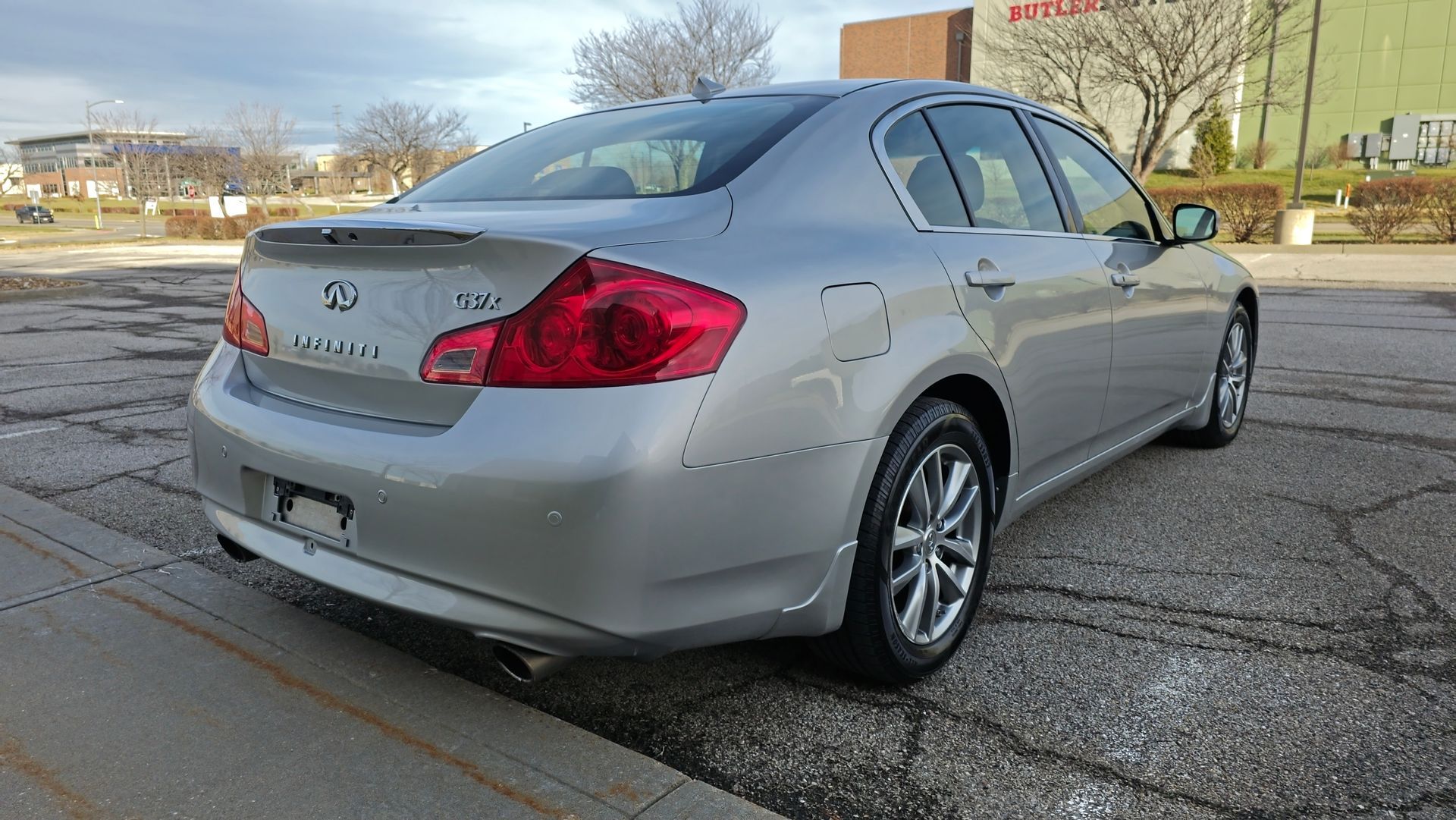 Silver Infiniti G37 sedan parked outdoors, rear view.