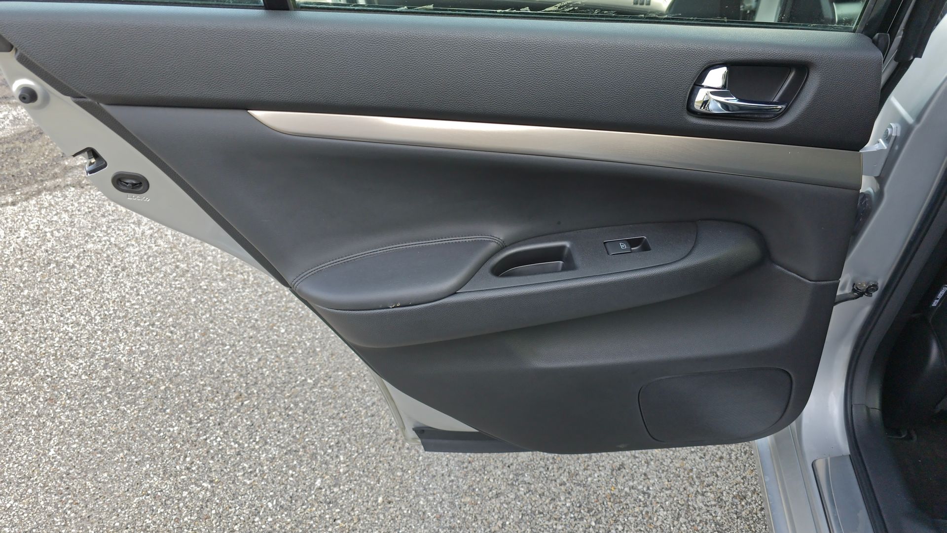 Interior car door with black and gray panels; window controls visible.