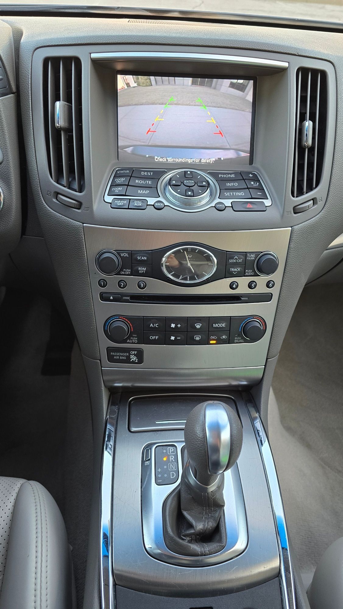 Car dashboard with center console, touchscreen, air vents, gear shift, and controls.