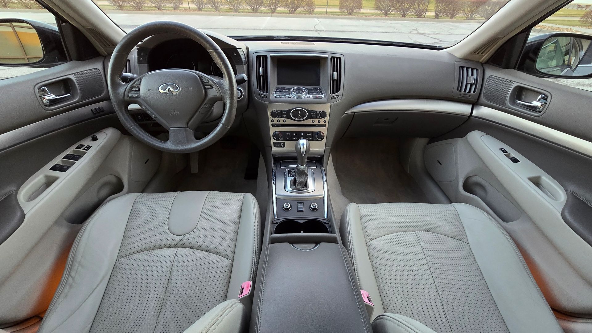 Interior of a car with gray seats, dashboard, steering wheel, and console.