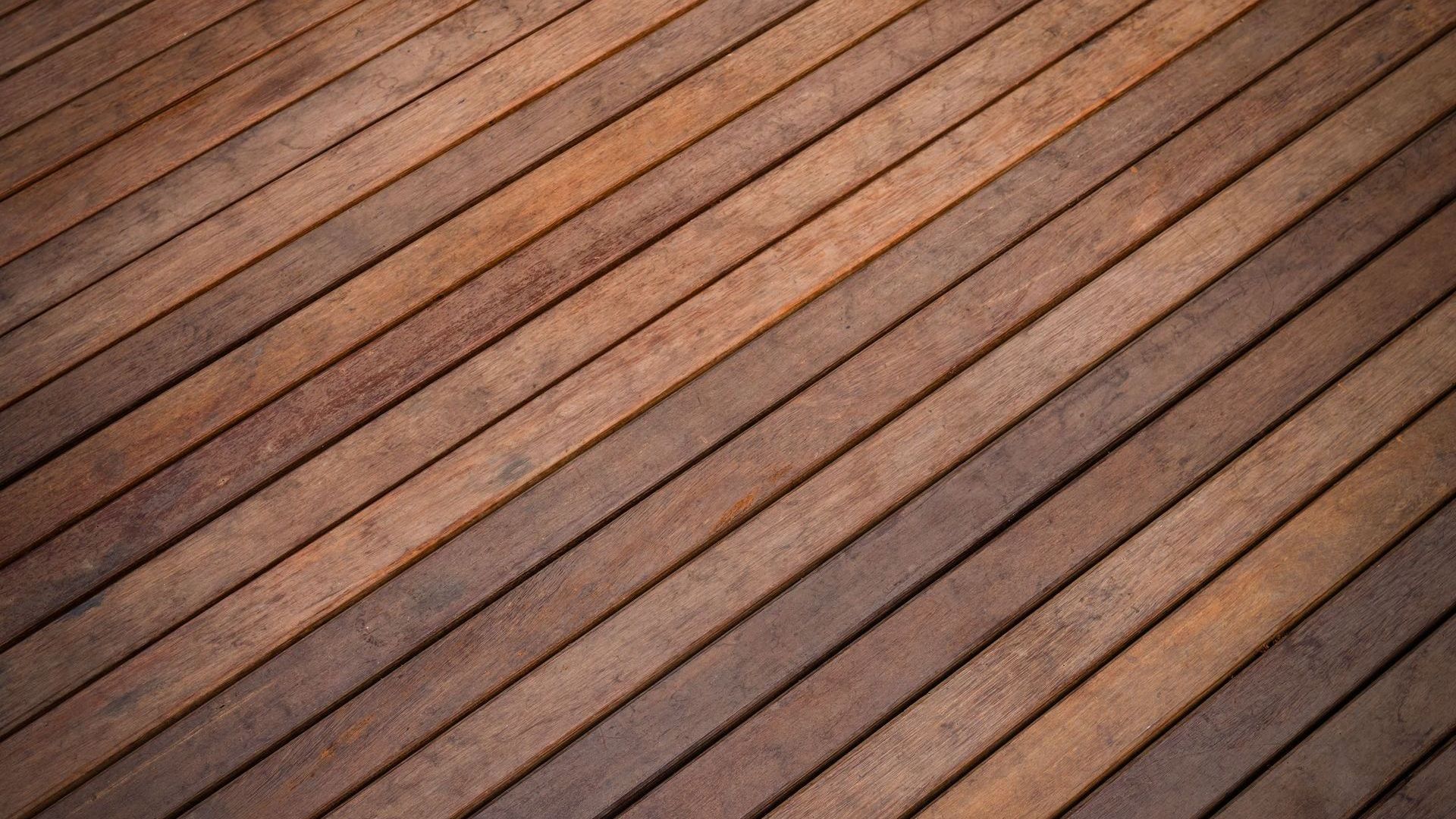 A close up of a wooden floor with a diagonal pattern.