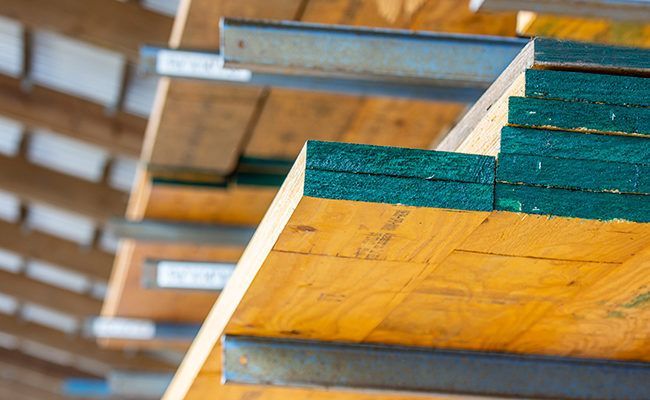 A stack of wooden boards sitting on top of each other on a shelf.