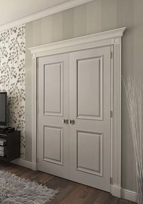 An empty room with white walls , a door , and two windows.