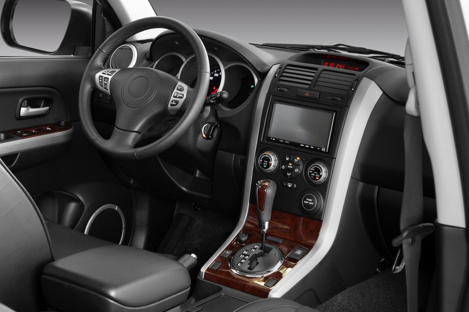 Car interior with black leather seats, center console, steering wheel, and touchscreen dashboard.