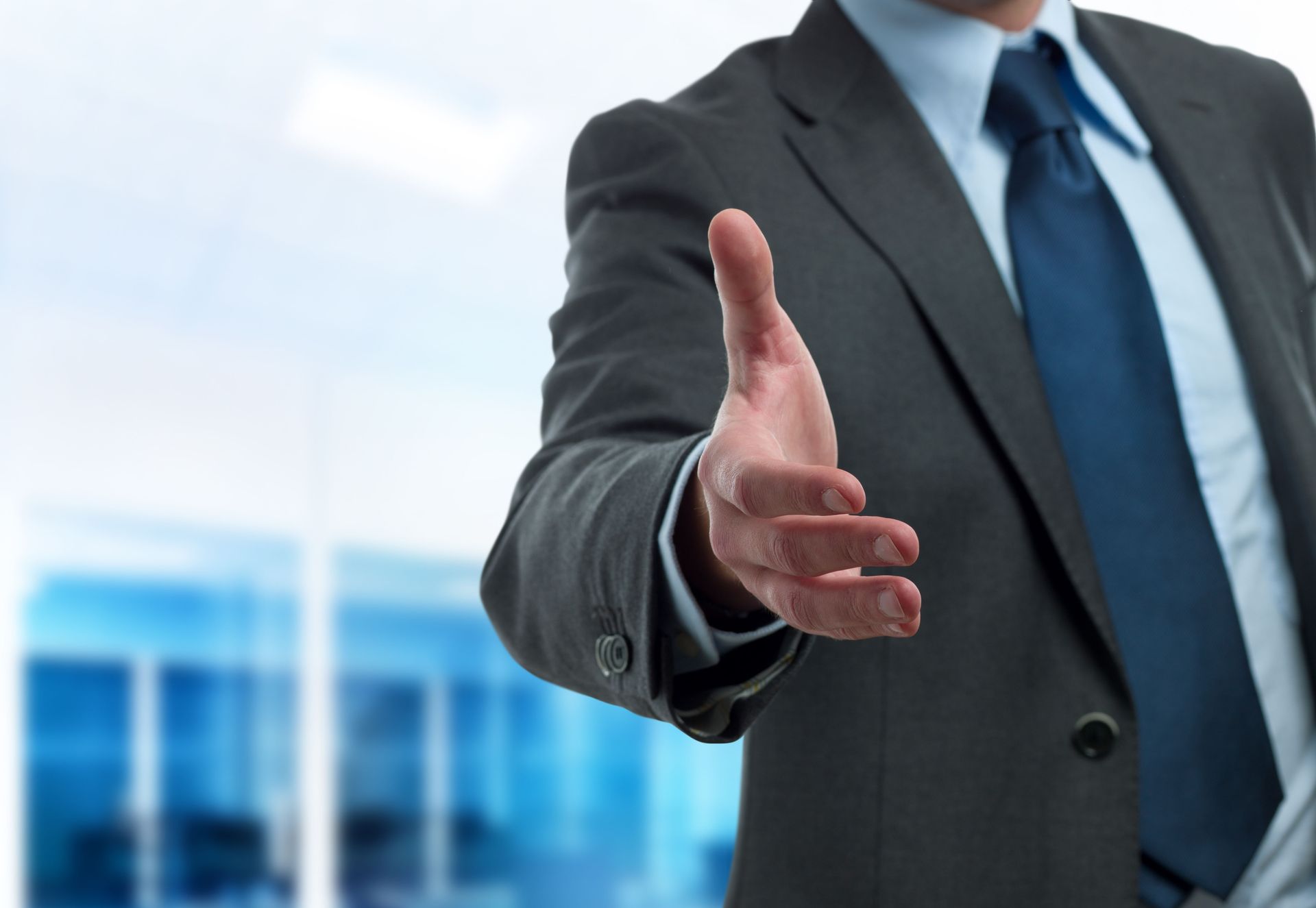 Businessman extending hand for a handshake in an office setting