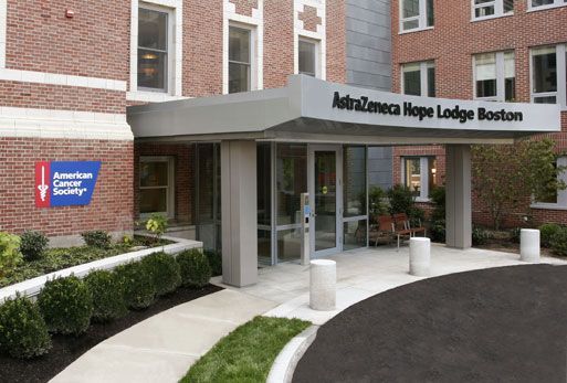 Entrance to AstraZeneca Hope Lodge Boston, a brick building with a canopy over the entrance, with a sign for American Cancer Society.