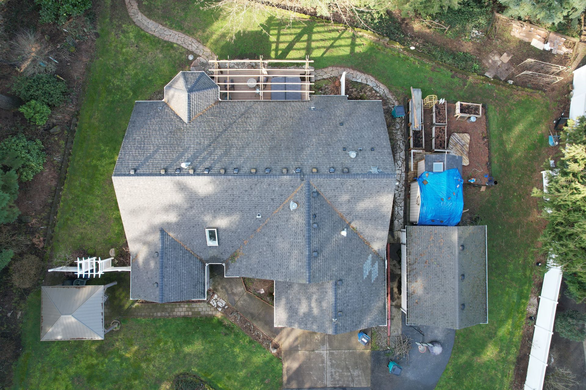 an aerial view of a house under construction with a blue tarp on the roof
