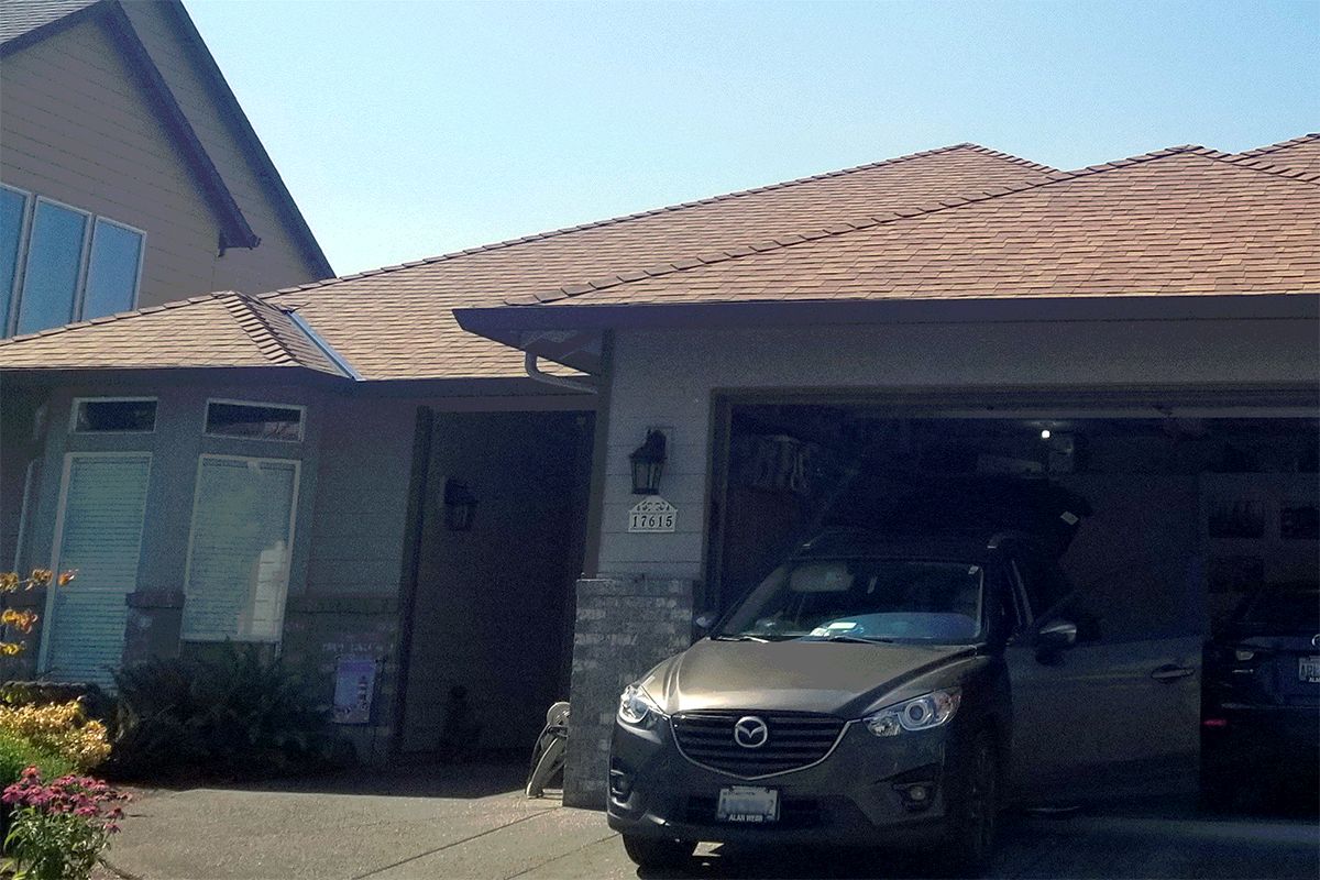 a car is parked in a garage in front of a house