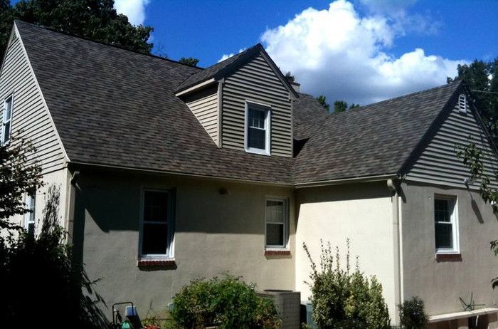 a white house with a brown roof and white windows