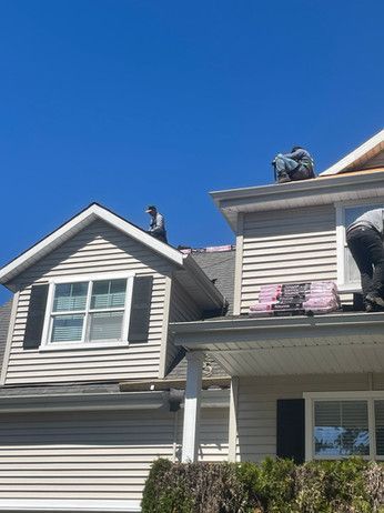 a man is working on the roof of a house